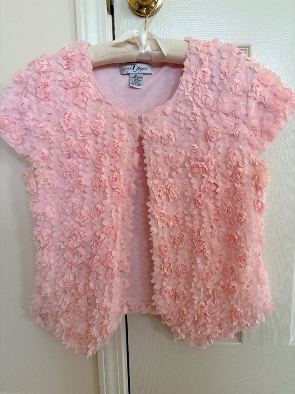 A pink 3D rosette textured short-sleeve top.